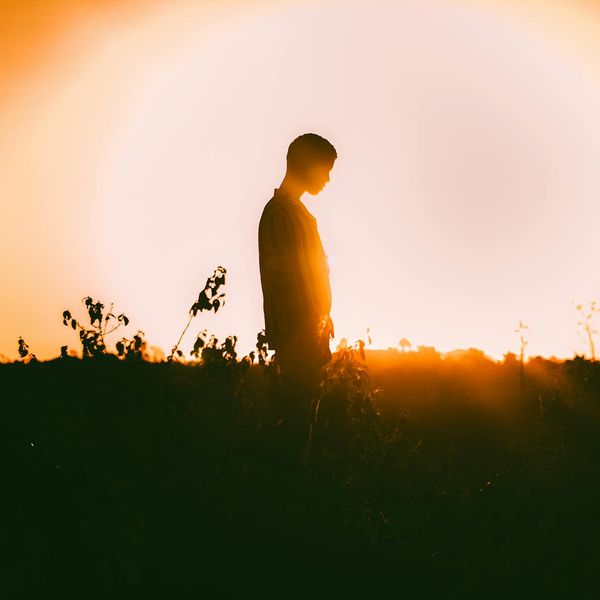 Persona meditando en un entorno natural al amanecer.